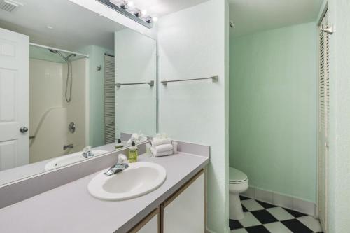 a white bathroom with a sink and a toilet at The Barbados by Brightwild-Bright Condo w Pool in Key West