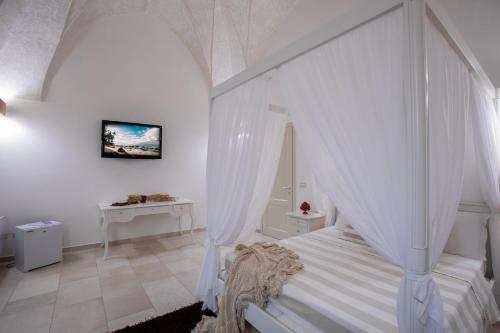 a bedroom with a white bed with a canopy at Il Torrino B&B in Sannicola