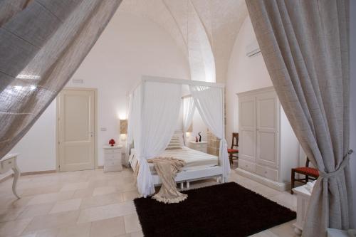 een witte slaapkamer met een hemelbed bij Il Torrino B&B in Sannicola