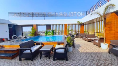 un patio del hotel con piscina, mesas y sillas en Hotel Grand Patliputra en Siwān