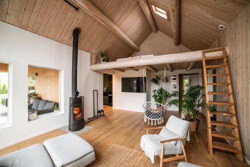 an open living room with a fireplace and a wooden ceiling at Dwa Słowa in Giżycko