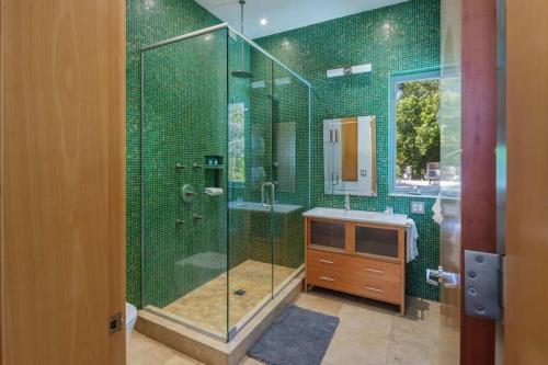 a green tiled bathroom with a shower and a sink at Contra House by Brightwild-Luxury Home With Pool in Key West