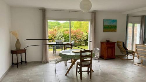 ein Esszimmer mit einem Glastisch und Stühlen in der Unterkunft Maison de 2 chambres avec jardin clos et wifi a Briscous in Briscous