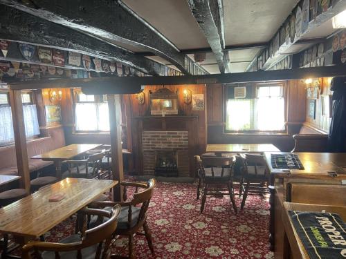 a restaurant with tables and chairs and a fireplace at The Jolly Drayman Pub and Hotel in Gravesend