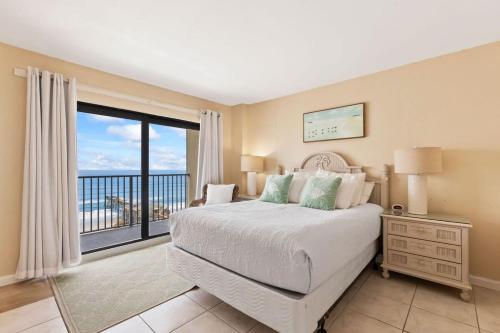 a bedroom with a bed and a large window at Oceanfront Condo with Amazing Views! Sunglow Resort 902 by Brightwild in Daytona Beach Shores