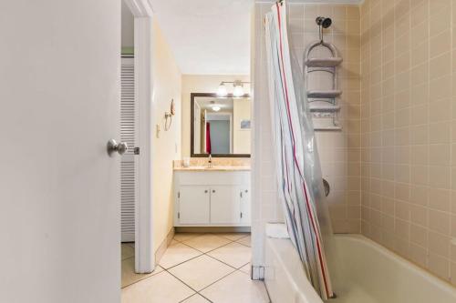 a bathroom with a shower with a tub and a sink at Ocean Front Condo with Amazing Views! Sunglow Resort 402 by Brightwild in Daytona Beach Shores