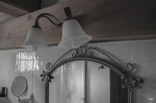 two lights are above a mirror in a kitchen at Mons Major Relais in Montemaggiore al Metauro