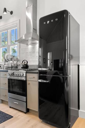 a kitchen with a black refrigerator and a stove at Casa Julieta - Stunning Ybor Studio in Tampa