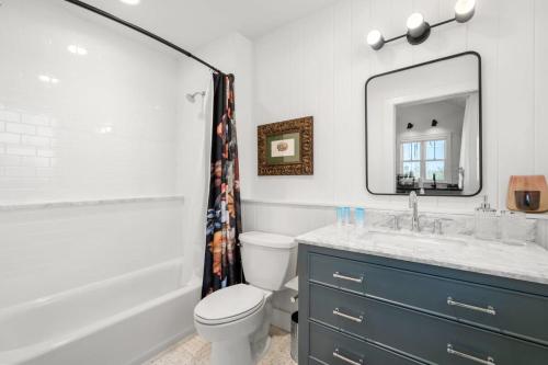 a bathroom with a sink and a toilet and a mirror at Casa Julieta - Stunning Ybor Studio in Tampa