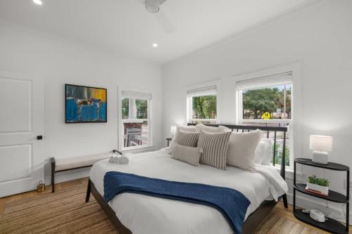 a white bedroom with a large bed and windows at Casa Padrón - Gorgeous Home, Steps to 7th Ave in Tampa