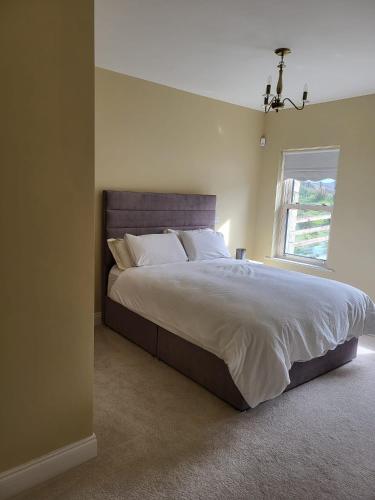 ein Schlafzimmer mit einem großen Bett und einem Fenster in der Unterkunft Ocean View in Ballycastle