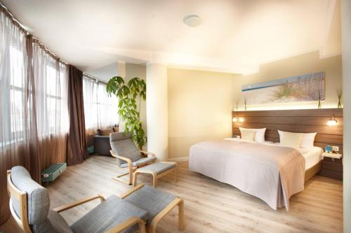 een hotelkamer met een bed en een stoel bij Hotel Kiel by Golden Tulip in Kiel