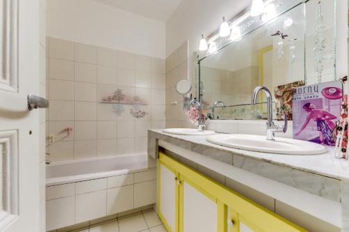 a bathroom with two sinks and a tub at Appartement lumineux au calme in Paris