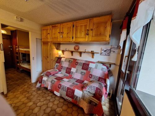 une chambre avec un lit avec une couette dessus dans l'établissement Studio à la montagne - Portes du Soleil, à Abondance