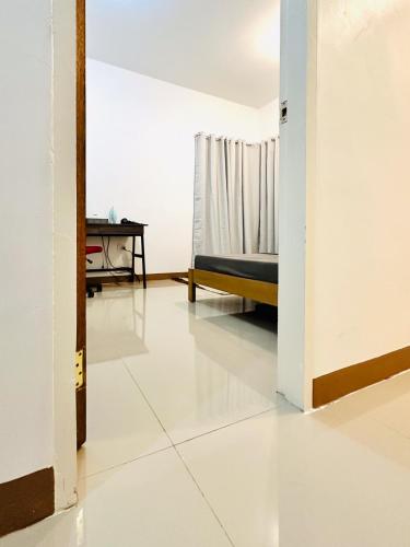a room with a bed and a white floor at Feel at Home Gateway H&C Shower Netflix 100mbps in General Santos