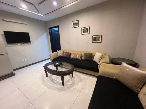 a living room with a couch and a table at Bahria Town Lahore - NEXT INN Condo available at Best Price 402 in Lahore