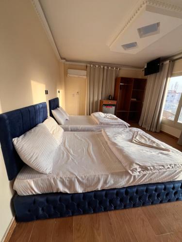 uma cama grande num quarto com uma moldura azul em Sphinx and Pyramids INN em Cairo