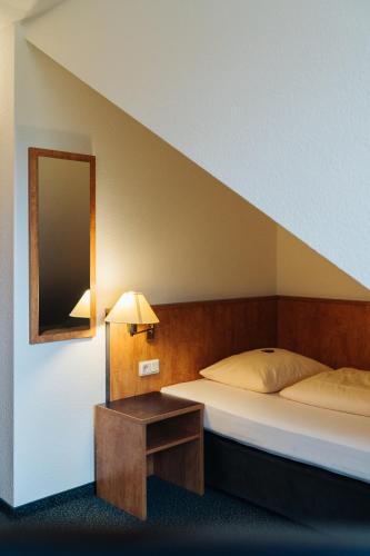 a bedroom with a bed and a mirror and a table at Hotel Stadt Gehrden in Gehrden