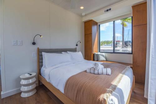 una camera da letto con un grande letto con una grande finestra di Awai's Floating Villa - Houseboat in Luxury Village a Key West