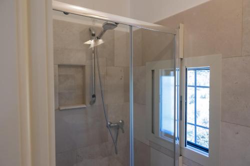 a shower with a glass door and a window at Il Torrino B&B in Sannicola