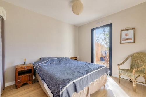 una camera da letto con un letto, un tavolo e una finestra di Déconnexion à Saint-Vincent-sur-Jard a Saint-Vincent-sur-Jard