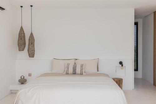 - une chambre blanche avec un grand lit blanc dans l'établissement Villa Scorcio: 3BR Tranquil Escape in Pererenan, à Canggu
