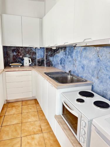 a kitchen with a white stove and a sink at Parthenis appartments in Pythagoreio
