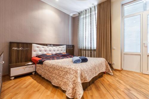 a bedroom with a bed and a large window at Sweet Home Apartment in Tbilisi City