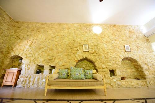 a stone wall with a couch in front of a stone fireplace at Abdelli Terraces in Batroun in Batroûn