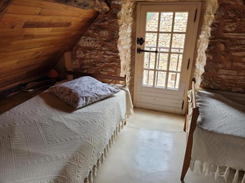 1 Schlafzimmer mit 2 Betten und einem Fenster in der Unterkunft Gîte Fournil in Varaire