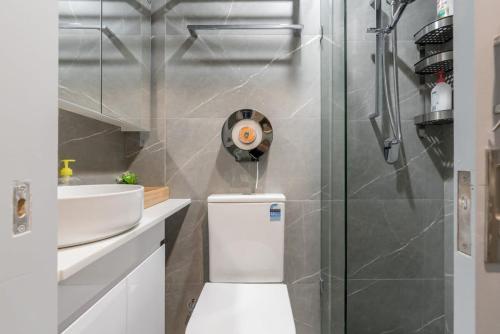 bagno con doccia e servizi igienici bianchi di Tiny Private Single Bed With In Sydney CBD Near Train UTS DarlingHar&ICC&Chinatown 1 - ROOM ONLY a Sydney