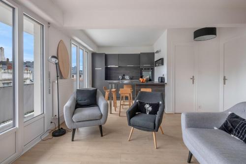 un salon avec deux chaises et un canapé ainsi qu'une cuisine dans l'établissement Découverte en duo en plein centre de la Baule, à La Baule