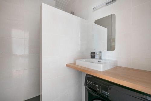 une salle de bain avec un lavabo et un miroir dans l'établissement Découverte en duo en plein centre de la Baule, à La Baule