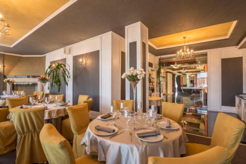 ツィゴフ・チャルクにあるComplex Katalinaの白いテーブルと黄色い椅子が備わるレストラン