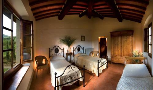 a bedroom with two beds in a room with windows at Palagina la cascina in Figline Valdarno