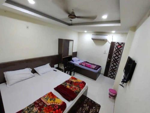 a bedroom with a bed and a desk in it at Swastik Guest House Inn Varanasi in Varanasi