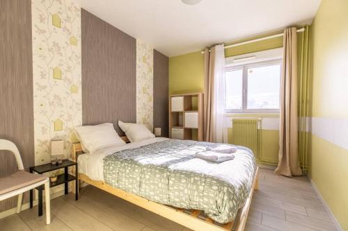 une chambre avec un grand lit et une fenêtre dans l'établissement Bel Appartement 8 couchages tout équipé- Maurice Thorez, à Clermont-Ferrand
