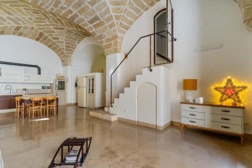 a large room with a staircase and a table and chairs at Relais Palazzo Zaccaria in Matino