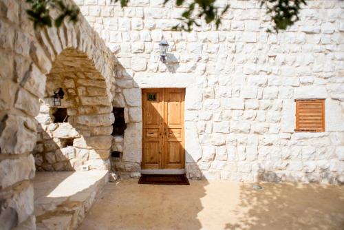 a stone building with a wooden door in it at Abdelli Terraces in Batroun in Batroûn