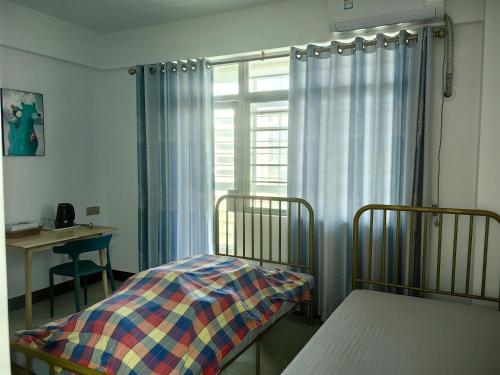 a bedroom with two bunk beds and a window at Cozy home of Orchid in Haikou