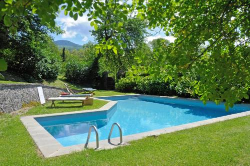 a swimming pool in the grass with a bench next to it at Casa di Pietro in Vivo d'Orcia, Pool in Vivo dʼOrcia