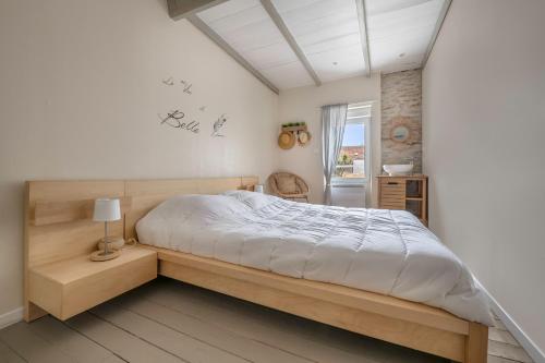 a bedroom with a large bed and a window at Maison pour 7 avec piscine à Préfailles in Préfailles