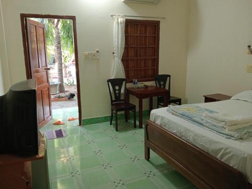 a bedroom with a bed and a table and chairs at Homestay Nhật Thi in Mui Ne