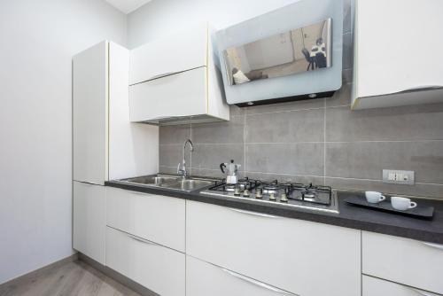 a kitchen with a sink and a tv on the wall at Orto Botanico Family Flat by Wonderful Italy in Naples