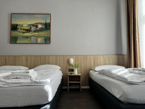 two beds in a room with a picture on the wall at Hotel Kieler Hof am Hauptbahnhof - Hamburg Central Station in Hamburg