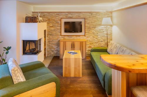 a living room with a couch and a fireplace at Wander- und Wellnesshotel Kanzler in Bad Mitterndorf