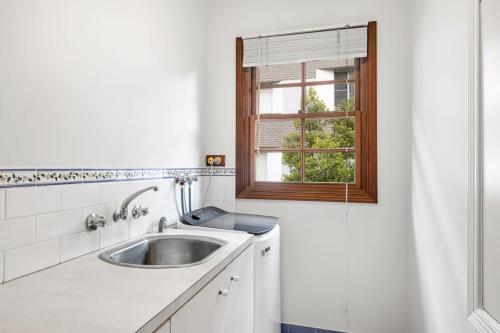 a white kitchen with a sink and a window at Quadruple Room in Gordon near Train & Bus Sleeps 4 in Pymble