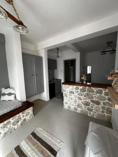 a living room with a stone fireplace and a couch at Elenis Studios&Apartments in Masouri
