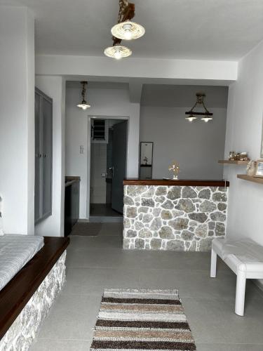 a living room with a stone fireplace and a couch at Elenis Studios&Apartments in Masouri