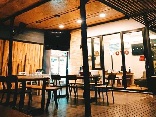 Pak Chong的住宿－T-PARK​ PAKCHONG​ ทีปาร์ค​ ปากช่อง，餐厅内带桌椅的用餐室